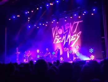 a group of people on a stage with a crowd watching
