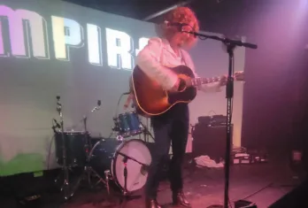 a person standing on a stage playing instruments