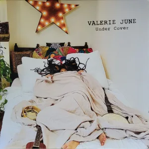 Album cover - color photo of Valerie June in bed, under the covers 