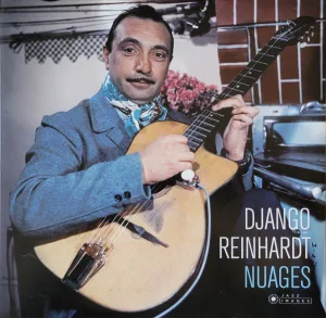 Django Reinhardt holding a guitar (photo from 1953)