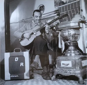 Django Reinhardt holding an electric guitar, black & white photo from 1953