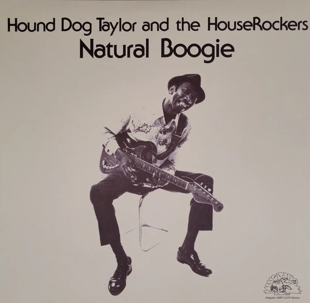 Album cover - photo of Hound Dog Taylor with a guitar on a stool 